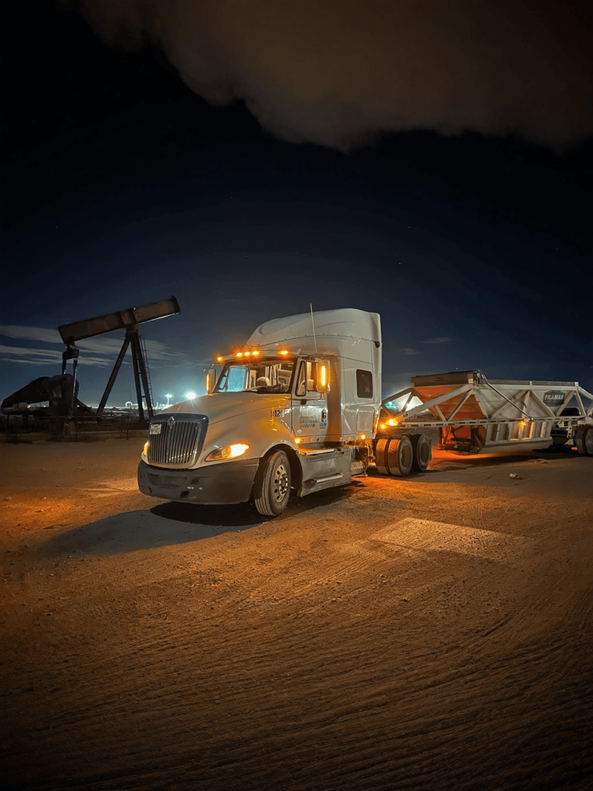 Belly dump trailer at oilfield at night